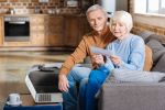 Payment notification. Serious unhappy elderly woman sitting together with her husband and looking at the document while holding it